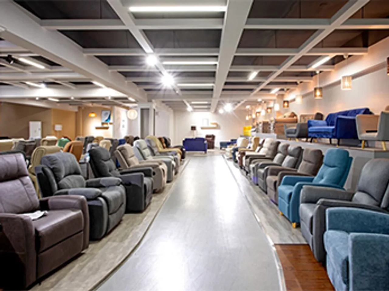 Rows of upholstered reclining cinema and lounge seating in a showroom